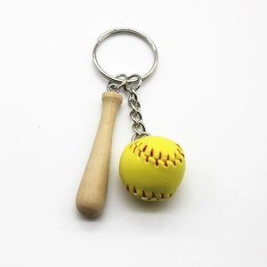 Close-up of a mini wooden baseball bat and yellow softball sports keychain gift