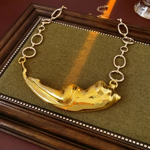 Détail macro du pendentif liquide doré brillant avec des maillons de chaîne épais