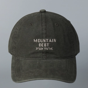 Λεπτομέρεια του λευκού κεντήματος Mountain Best στο σκούρο γκρι βαμβακερό καπέλο