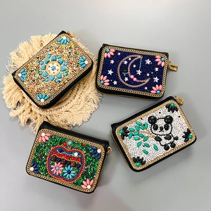 Handmade Bohemian beaded mini purses with panda and floral patterns on woven mat