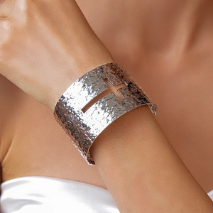 Detailed view of wide textured silver metal cuff featuring a hollow cross cutout