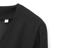 Gros plan sur la texture du tissu de robe noire en V et l'étiquette de taille S