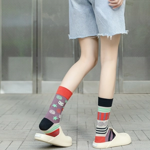 Close-up of asymmetric patterned mid-calf socks with purple cat and colorful stripe design
