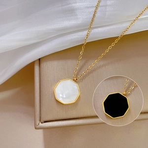 Detail view of gold titanium steel necklace with white and black hexagonal shell pendants