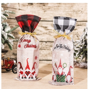 Detail of Christmas burlap wine bottle covers with red and black plaid and gnome prints
