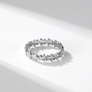 Stackable silver star-shaped titanium steel ring for women on a minimalist background