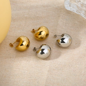 Polished gold and silver chunky half-moon hoop earrings on beige linen background