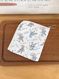 Pochette en tissu matelassé avec imprimé fille cartoon et zip en métal sur bois