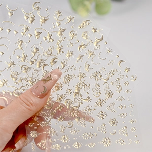 Detail of champagne gold moon and flower nail stickers with metallic adhesive finish