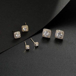 Detailed set of three golden square halo earrings with clear cubic zirconia in varied sizes