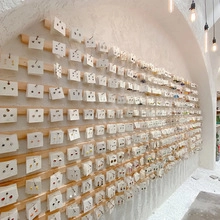 Retail wall display of various Chinese style earrings on white cards on wooden shelves