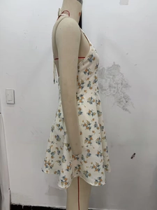 Vue latérale d'une robe dos nu en popeline à fleurs blanches avec un motif floral vif