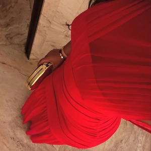 Detail of red sleeveless midi dress showing elegant waist ruching and silky texture