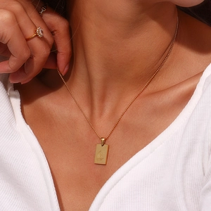 Close-up of 18K gold-plated necklace featuring a rectangle pendant with moon and star details