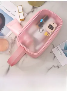 Detailed view of pink cartoon PVC makeup bag with reinforced handles on marble surface