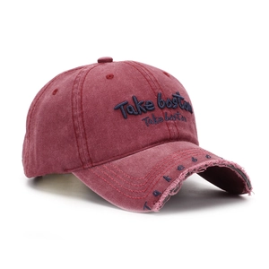 Detailed close-up of distressed cotton baseball cap in burgundy with Boston embroidery