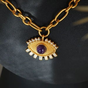 Macro shot of 18k gold plated evil eye pendant with purple zircon and thick chain