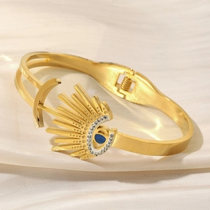 18K gold plated evil eye cuff bracelet with sunburst crystal design on silk background