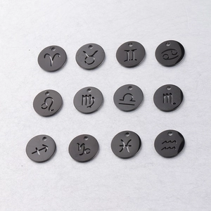 Macro detail of twelve black stainless steel circular charms with zodiac sign engravings