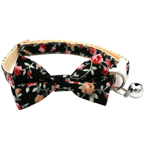 Detail of floral pet collar with white safety buckle, D-ring, and silver bell