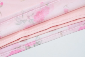 Primo piano del tessuto a rete floreale rosa con cuciture dettagliate sull'abito estivo aderente