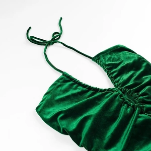 Detail van de groene fluwelen haltertop met rimpels en verstelbare nekbandjes