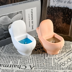 Macro shot of creative toilet-shaped scented candles in ceramic holders for home decor