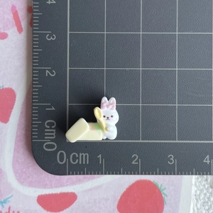 Detailed view of mini resin bunny charm showing dimensions of 1.5cm by 1.8cm