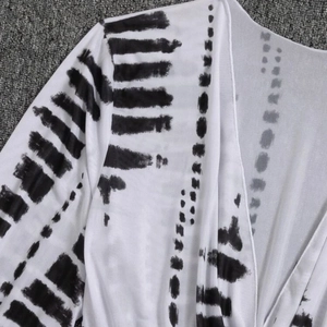 Three-piece bikini set featuring white sheer long-sleeve cover-up with black ink prints