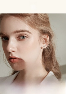Close-up of model wearing silver curved earrings with gradient sparkling zircon stones