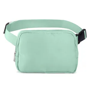 Detail view of mint green nylon waist bag with silver zipper and adjustable buckle strap