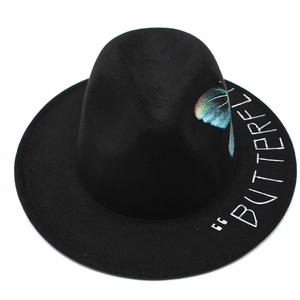 Close-up of a black wool fedora hat with colorful butterfly print and script text