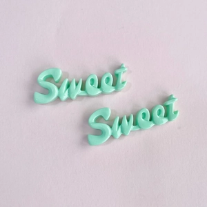 Gros plan de deux charms Sweet en résine vert menthe pour pinces à cheveux et bricolage
