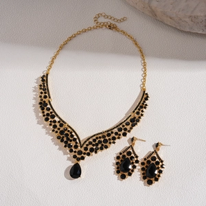Vintage gold V-shaped necklace and drop earrings set with black crystals and pear-shaped gems