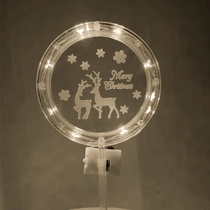 Detail of glowing Merry Christmas cake topper with LED reindeer and snowflake engraving