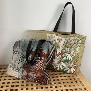 Close-up of floral and animal jacquard patterns on two large canvas tote bags with wide straps