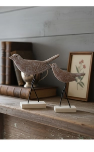 Detailopname van vintage houten vogelbeeldjes met metalen poten op een massief houten voet