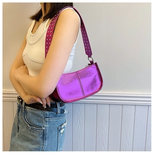 Close-up of metallic purple PU shoulder bag with decorative silver rivets on the wide strap