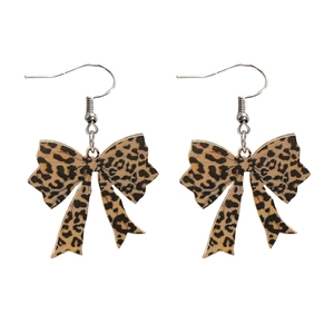 Detail of leopard print bow earrings with silver metal hooks on a white background