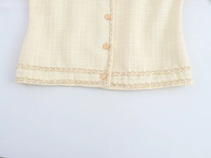 Détails de la veste en tweed beige avec boutons dorés et textures de bordure tissée