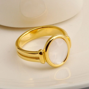 Minimalist 18K gold-plated oval white shell ring with ripple design on a ceramic plate