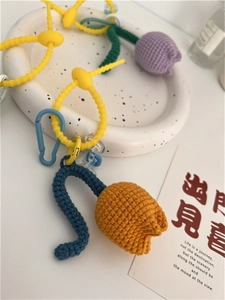 Detailed close-up of handmade crochet tulip charms in purple, yellow, and blue colors