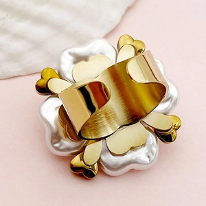 Macro detail of ornate flower ring featuring white faux pearls and gold heart metal accents
