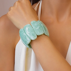 Macro view of light green marble texture acrylic rectangle bracelet on female wrist
