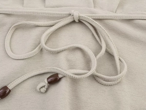 Dettaglio in lino di cotone beige con coulisse e perle in resina marrone scuro