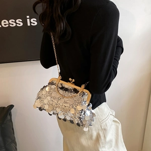 Silver sequin shell bag with gold clasp and chain strap shown on person in luxury style