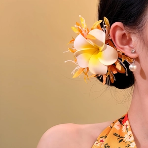 Nahaufnahme einer Frangipani-Stoffblumen-Haarklammer, die von einem Model getragen wird