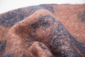 Macro shot of soft peach and grey jacquard textile texture with fuzzy wool-like fibers
