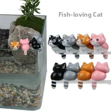 Detailed view of cat figurine ornaments hanging on aquarium edge in four distinct colors