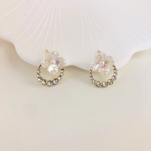 S925 silver flower bud earrings with pearl stamens and sparkling rhinestones on white tray
